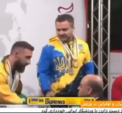 Активист приветствует украинского спортсмена, который отказался пожать руку иранским участникам